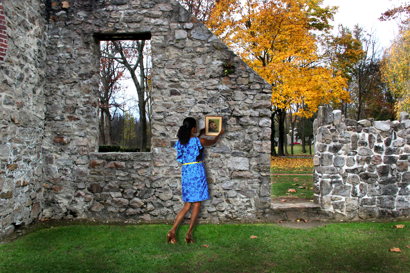 Composite image of women hanging a picture frame in the ruins of a building